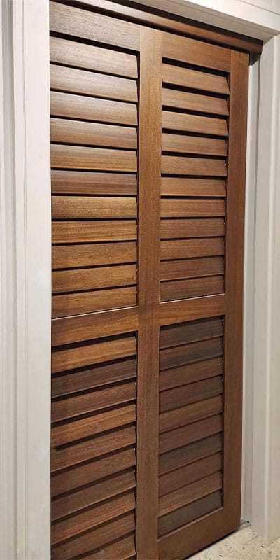 Dark wood timber shutter doors on narrow doorway