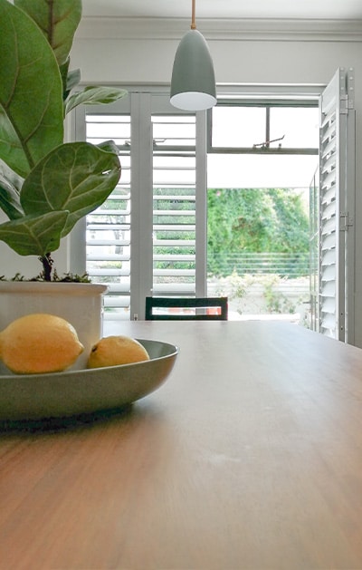 Timber shutters on French doors in bright dining room