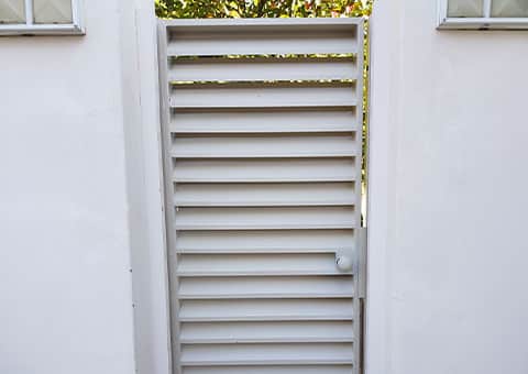 Magnador louvre swing gate in garden wall opening