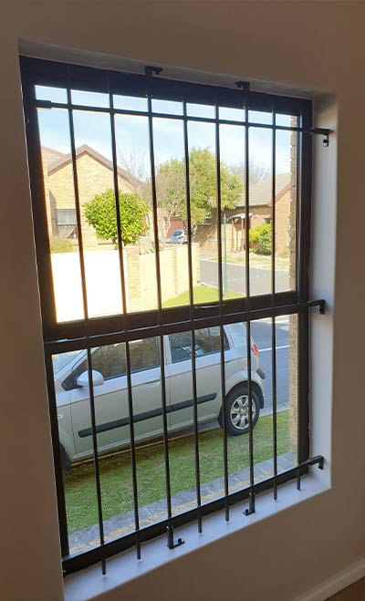 Black Mini Spanish burglar bars in vertical style with parked car and driveway view