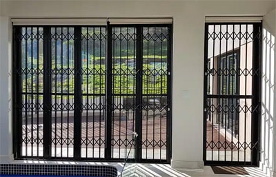 Black diamond-pattern Magnador Champion retractable grille on patio doors with garden view
