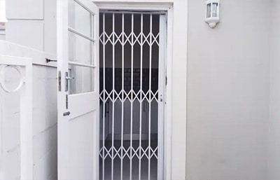 White diamond-pattern Alphador retractable grille behind an open white door